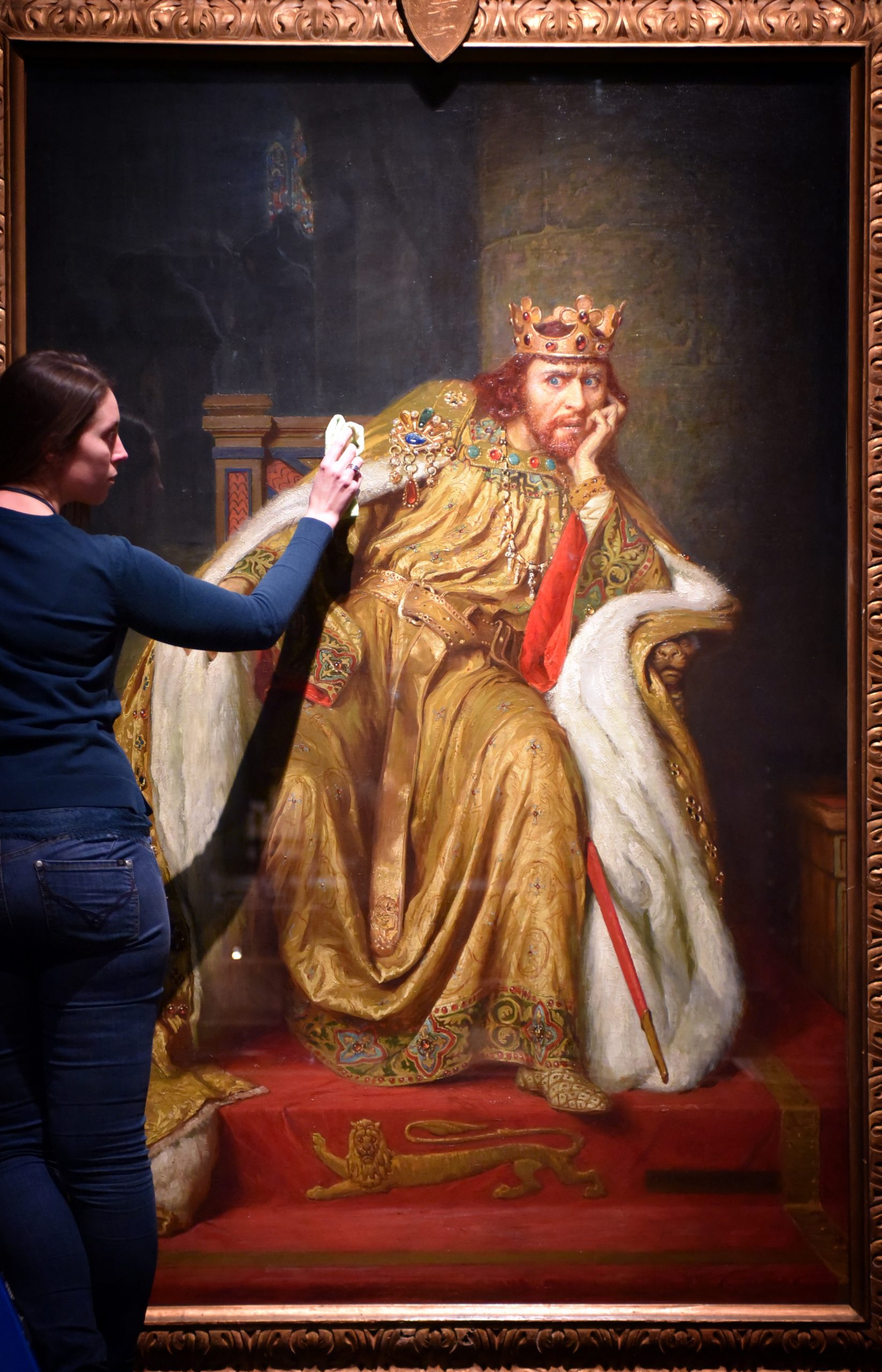A British Library exhibition officer dusts a painting on loan from The Victoria and Albert Museum to Magna Carta- Law, Liberty, Legacy. Photography © Clare Kendall